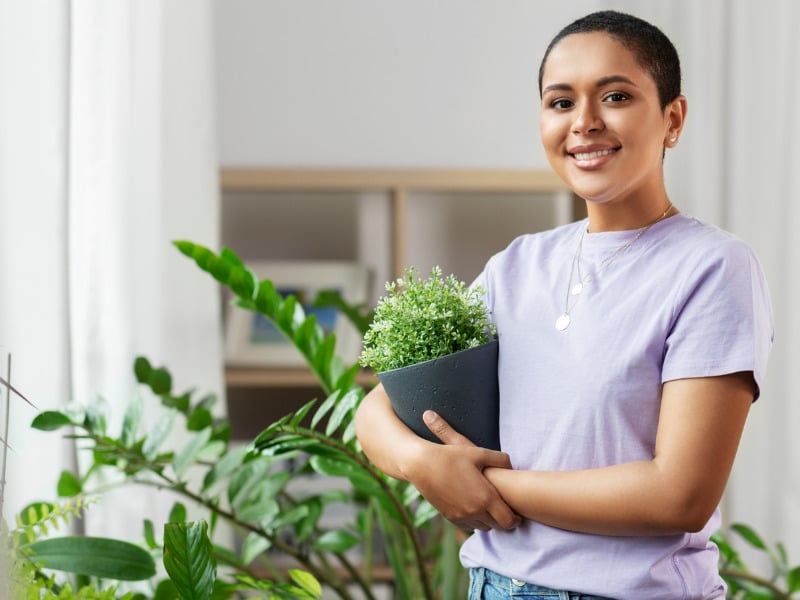 woman with plants smiling at camera